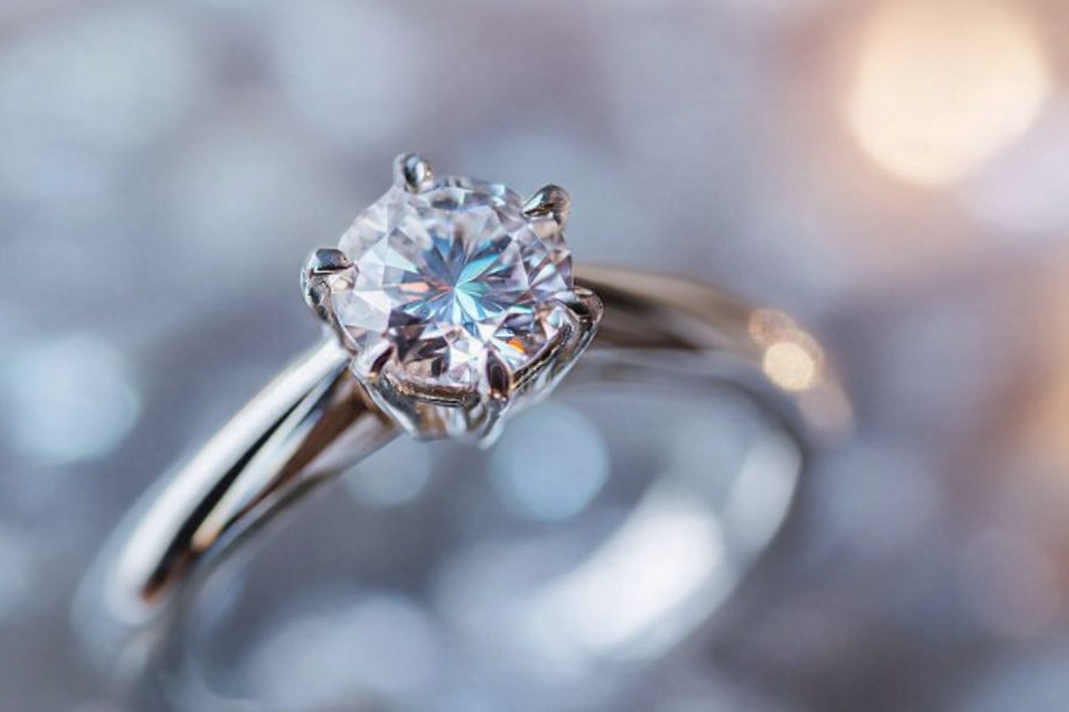 Närbild på en silverring med en stor, gnistrande diamant, redo att säljas via diamantbrev.se.